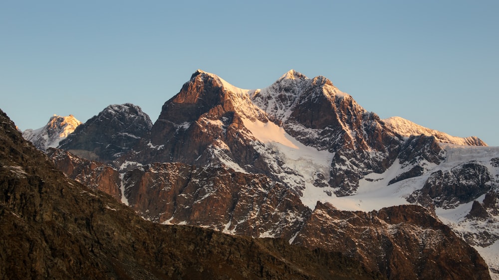 a snow covered mountain range with a clear sky