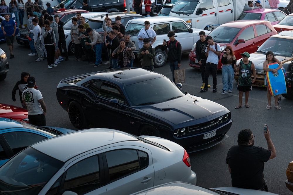 una multitud de personas de pie alrededor de un estacionamiento