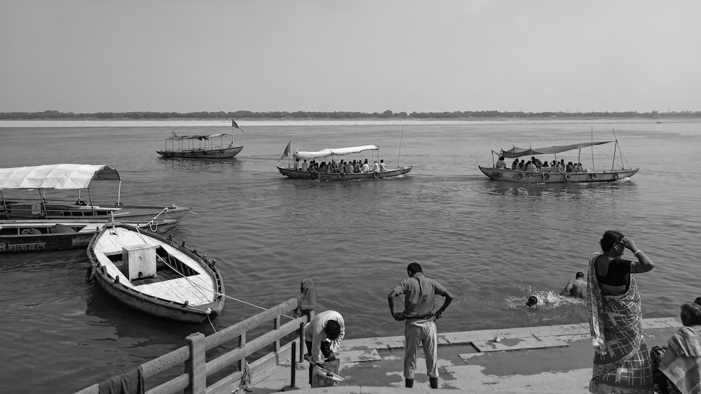 a group of people standing on a dock next to boats