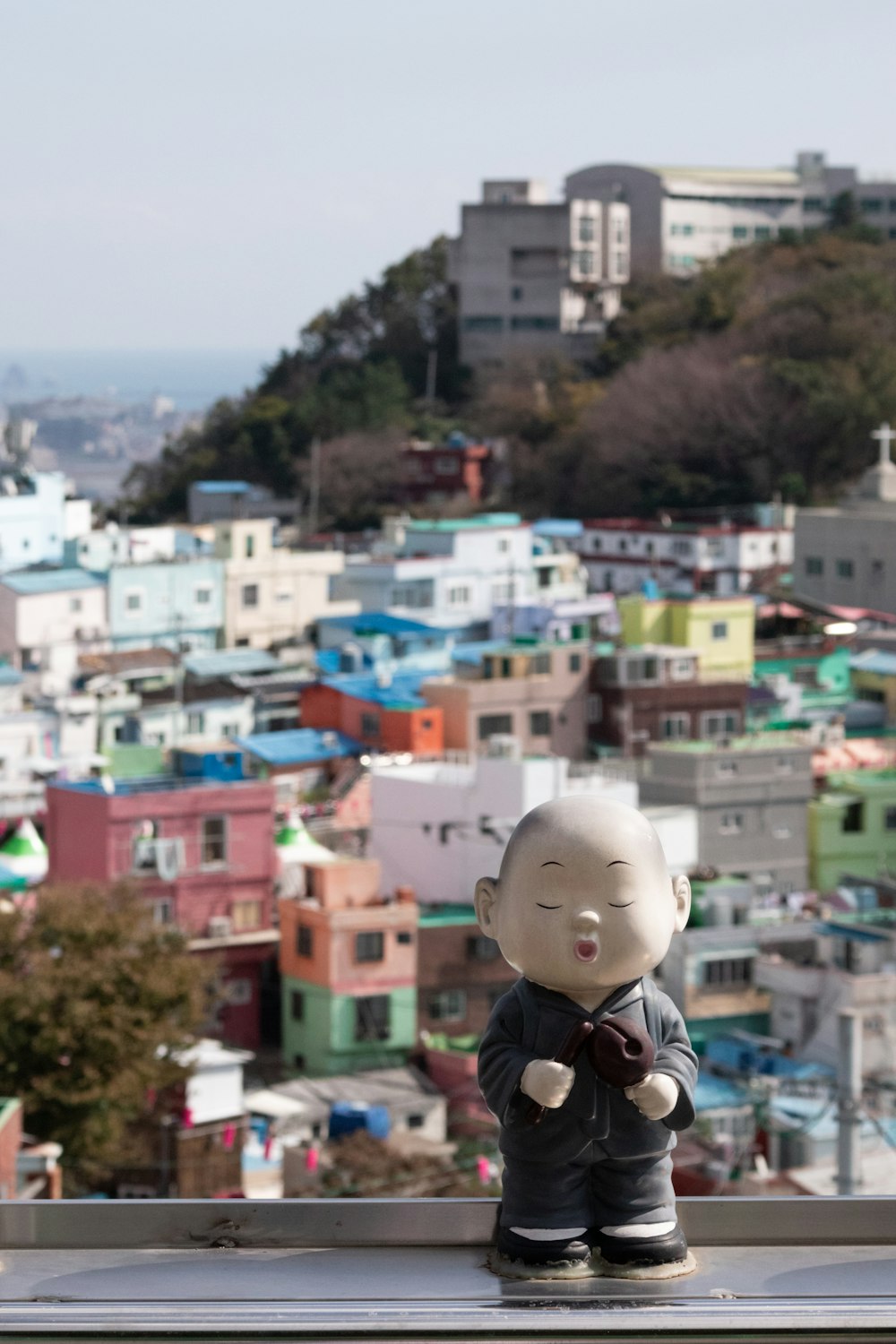 a small doll sitting on top of a window sill