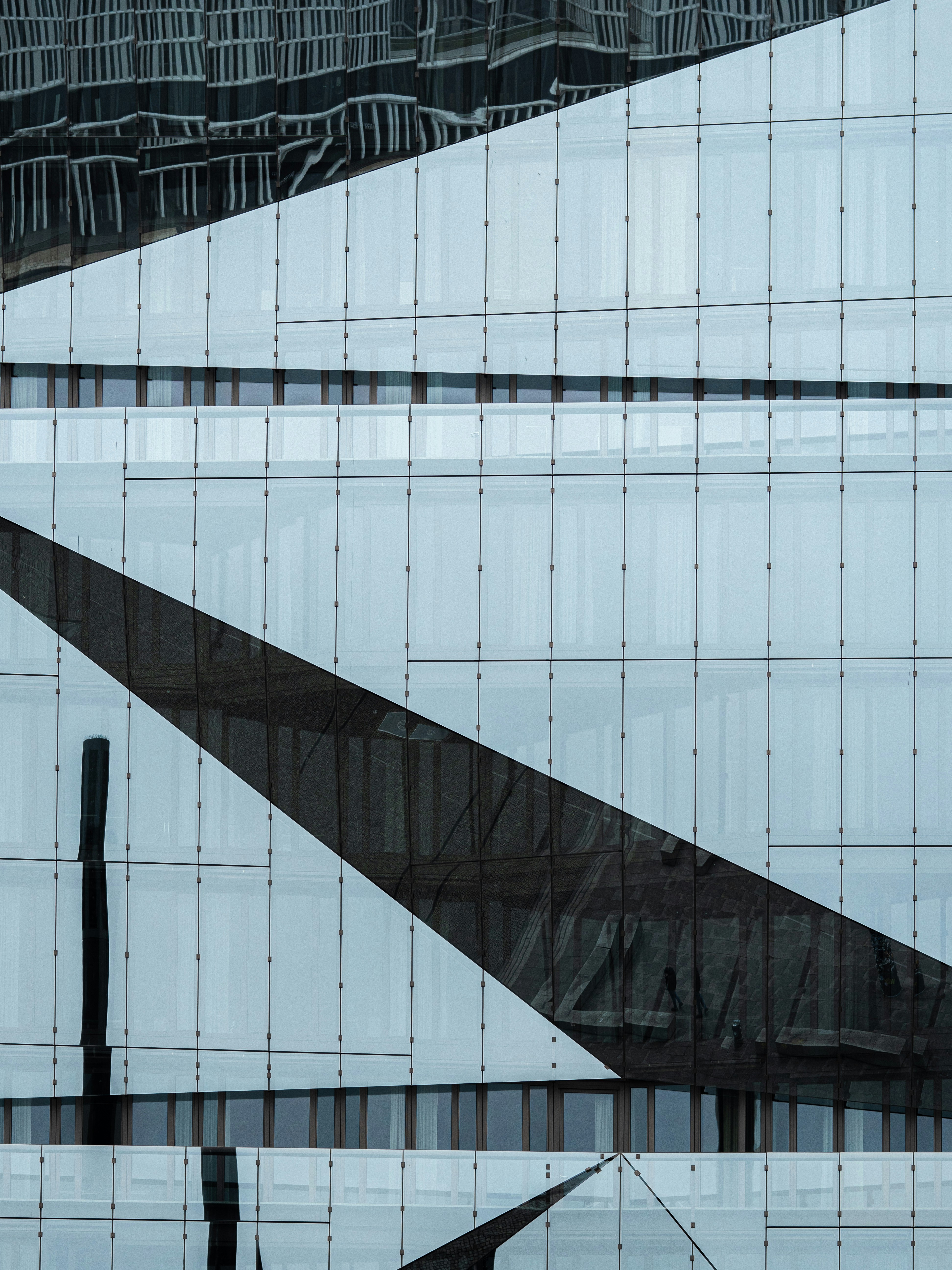 a very tall building with many windows reflecting it's architecture