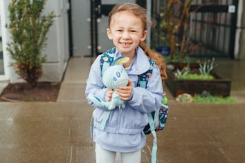 a little girl is holding a stuffed animal