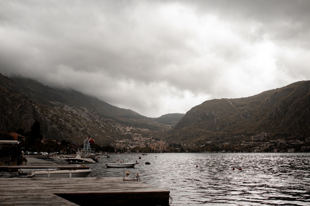 a body of water surrounded by mountains under a cloudy sky