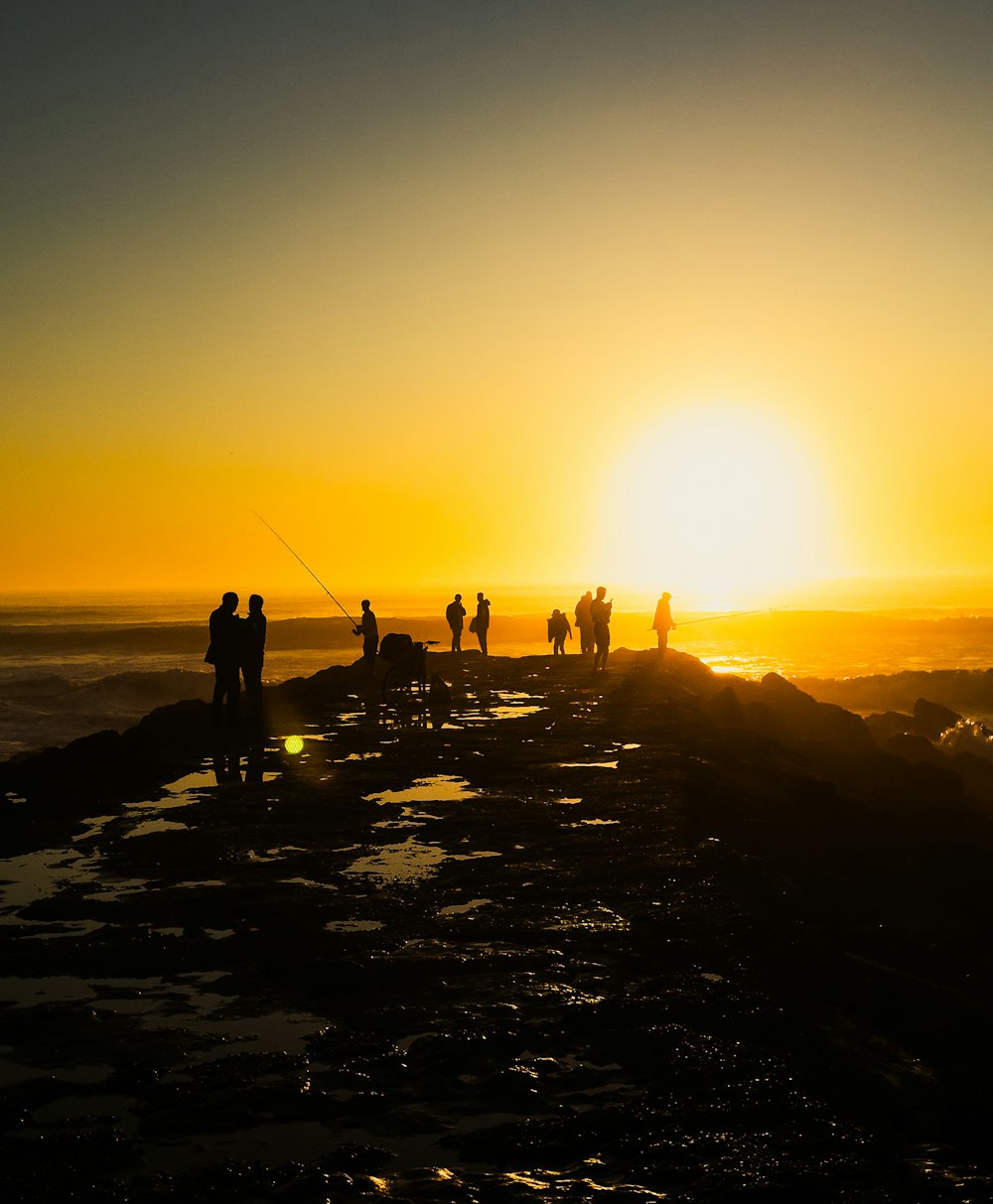 a group of people standing on top of a beach