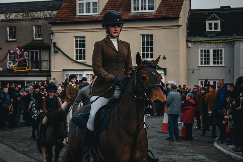 a woman riding on the back of a brown horse