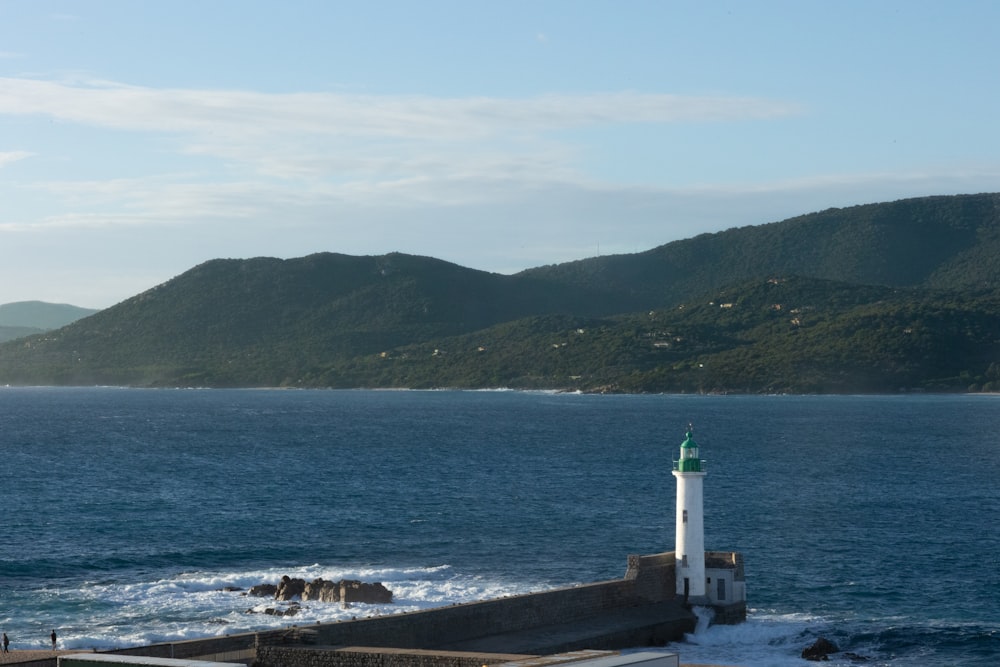 a lighthouse sitting on top of a pier next to the ocean