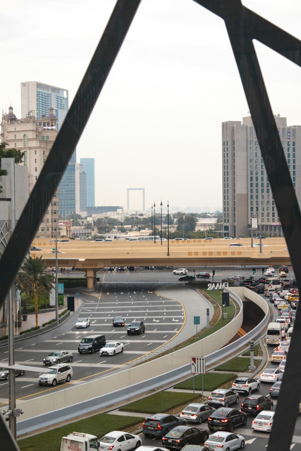 a highway filled with lots of traffic next to tall buildings