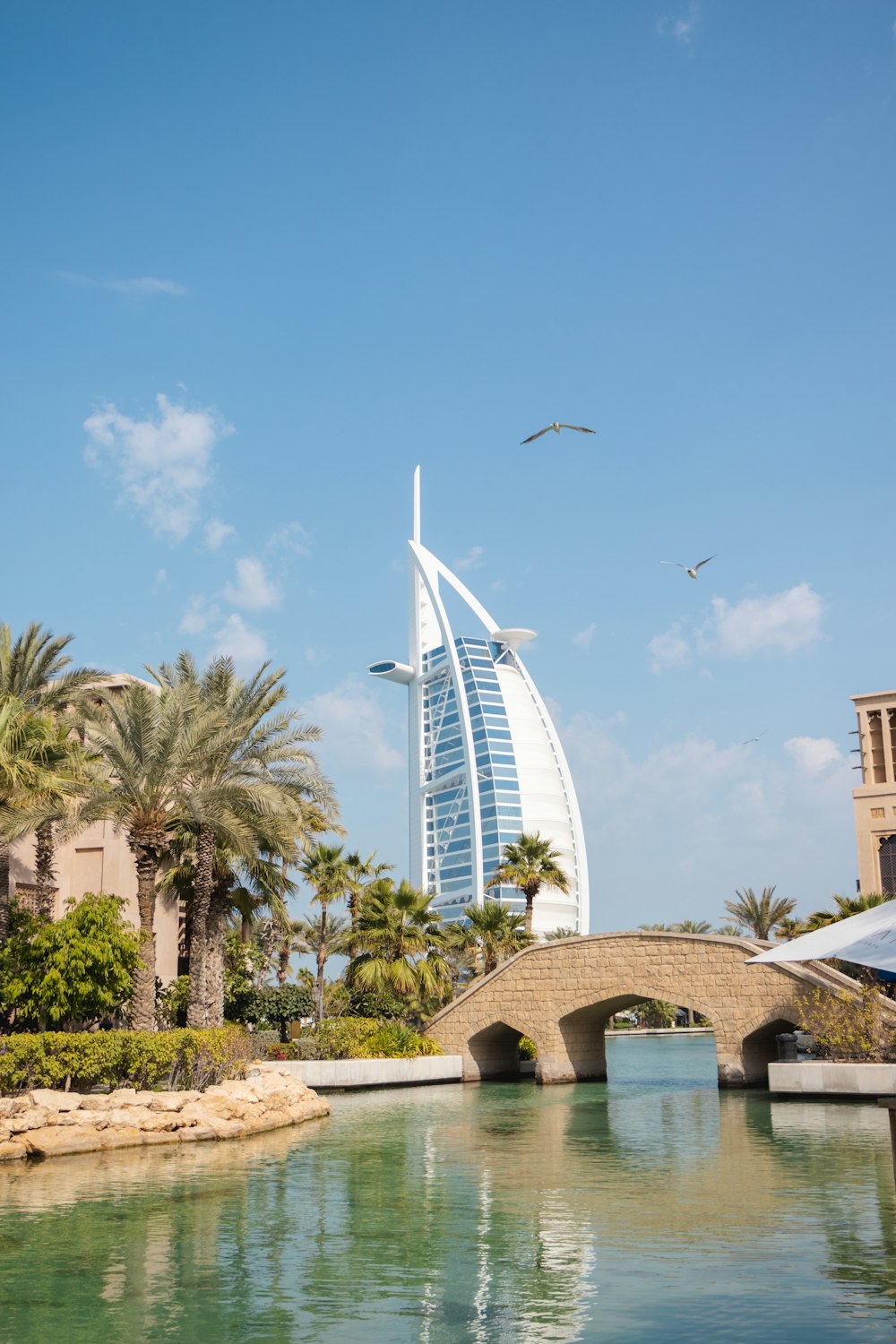 a bridge over a body of water with a tall building in the background