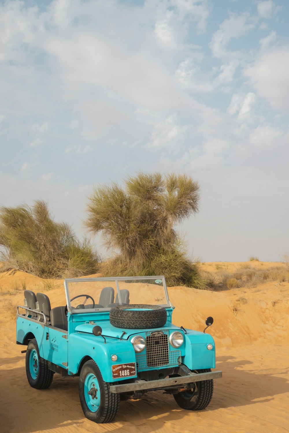 a blue jeep is parked in the desert