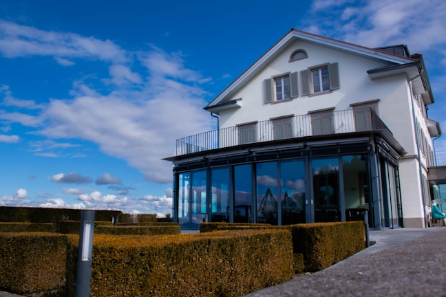 a large house with a lot of windows and a lot of hedges