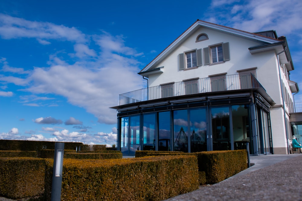 a large house with a lot of windows and a lot of hedges