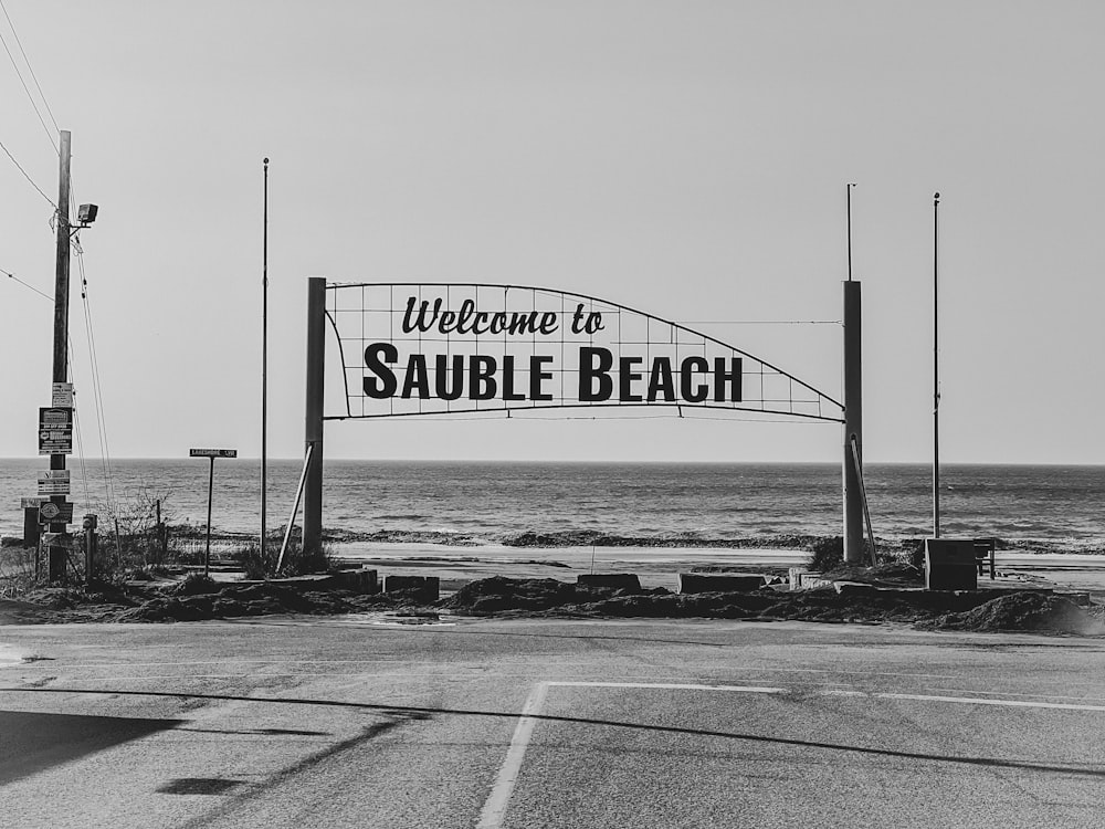 a welcome sign to a beach on a clear day