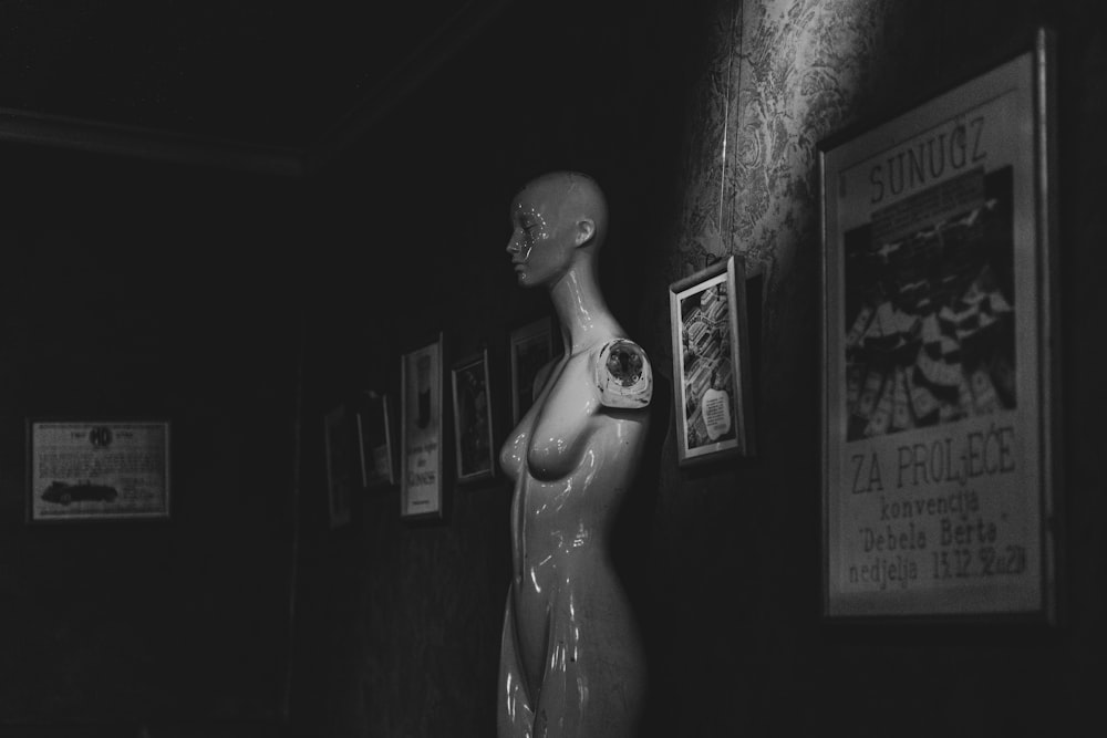 a black and white photo of a mannequin in a dark room