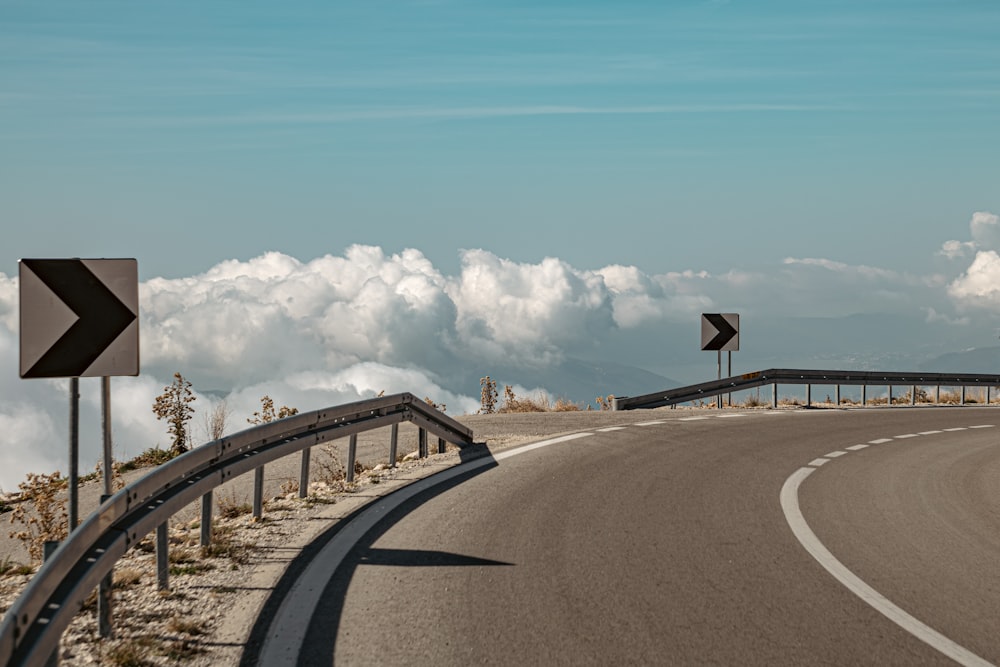 a curved road with a sign on the side of it