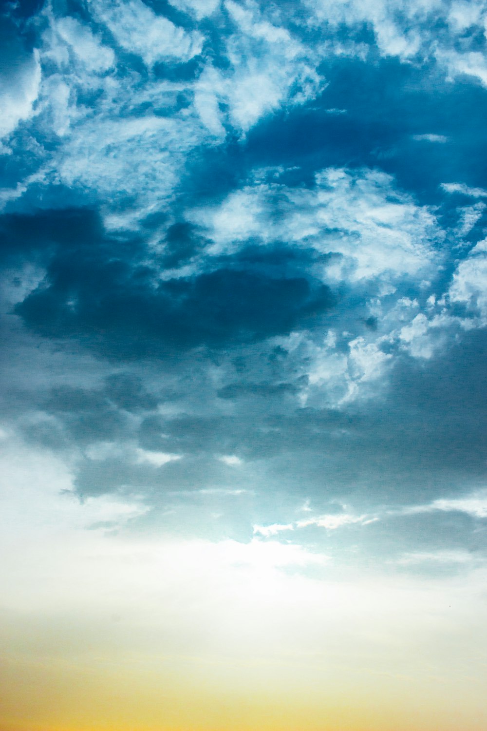 a group of people standing on top of a beach under a cloudy sky