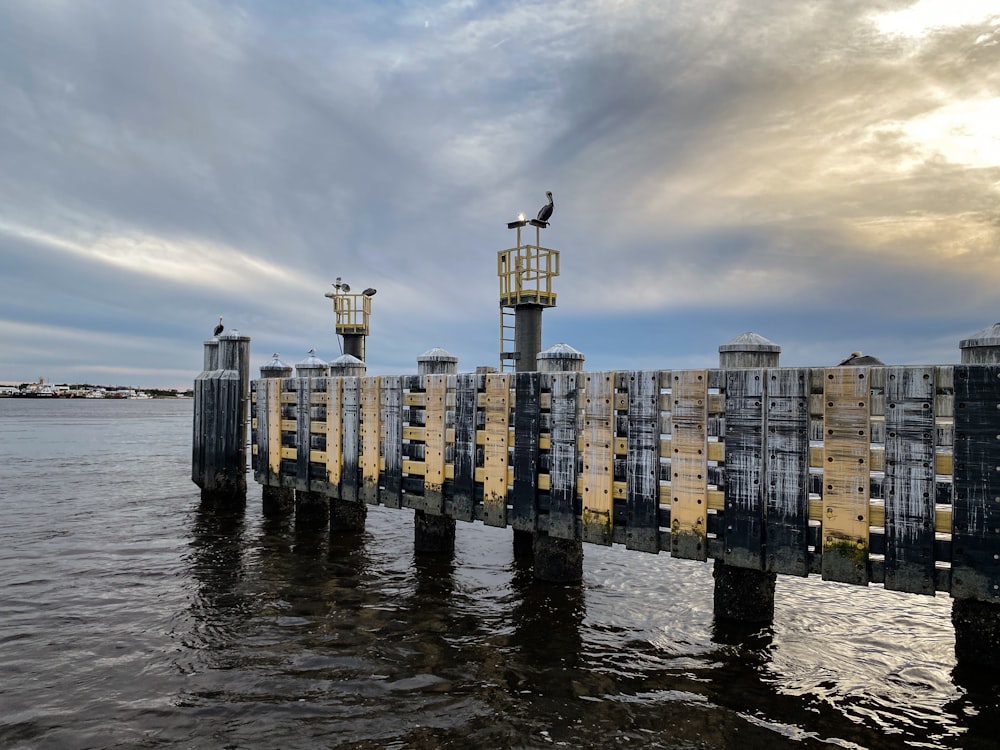 a pier with a bird sitting on top of it