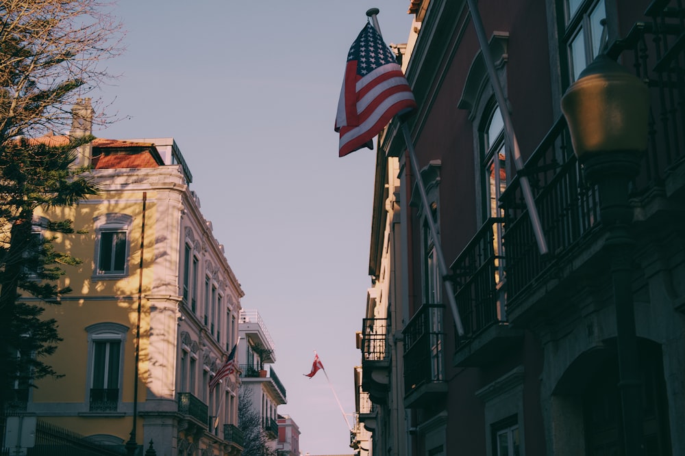 an american flag flying in the air between two buildings