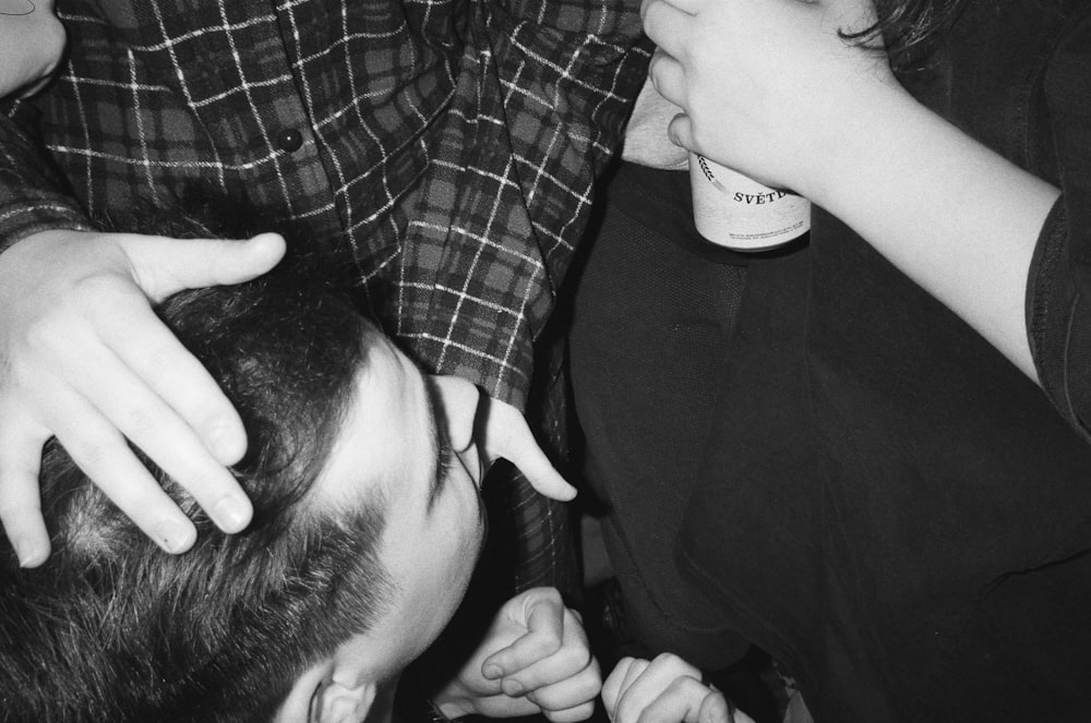 a black and white photo of a man getting his hair cut