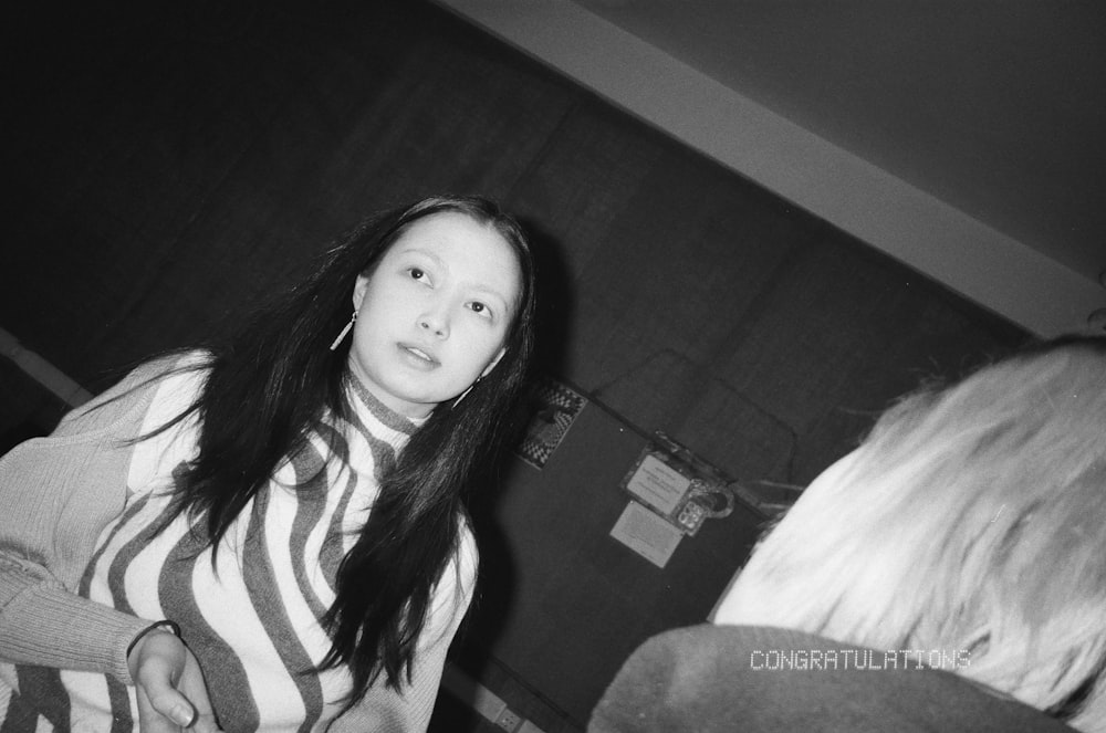 a woman with long hair standing in front of a mirror