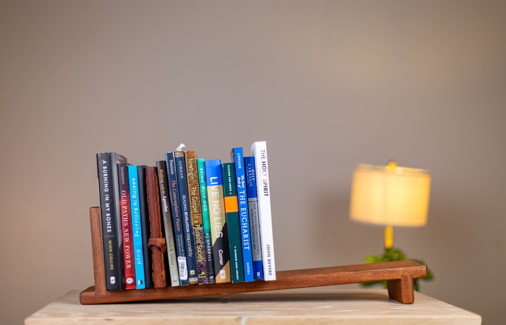 a wooden shelf with a lamp and books on it