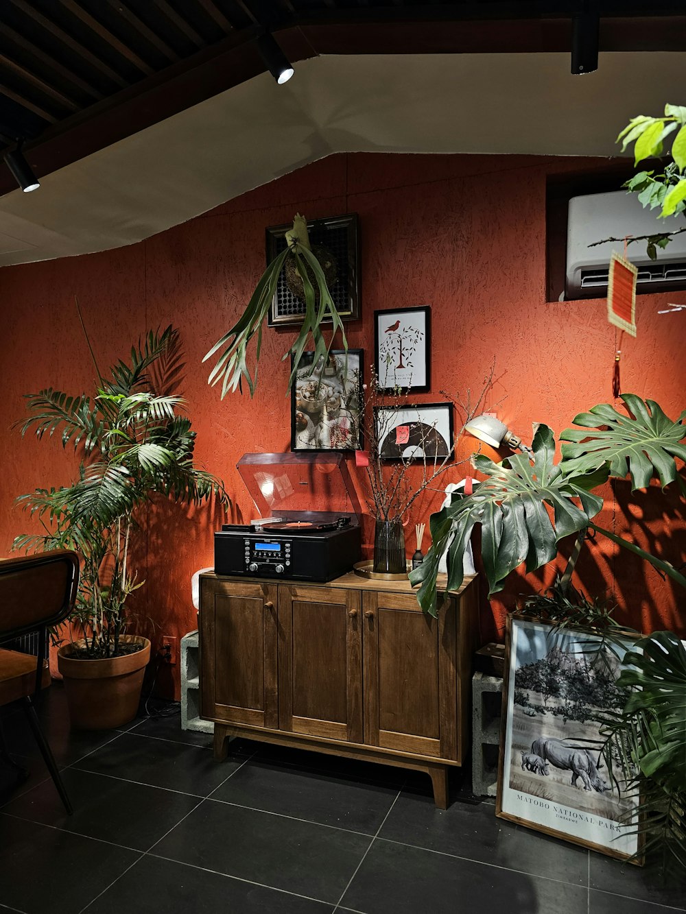 a room with a record player, plants and pictures on the wall