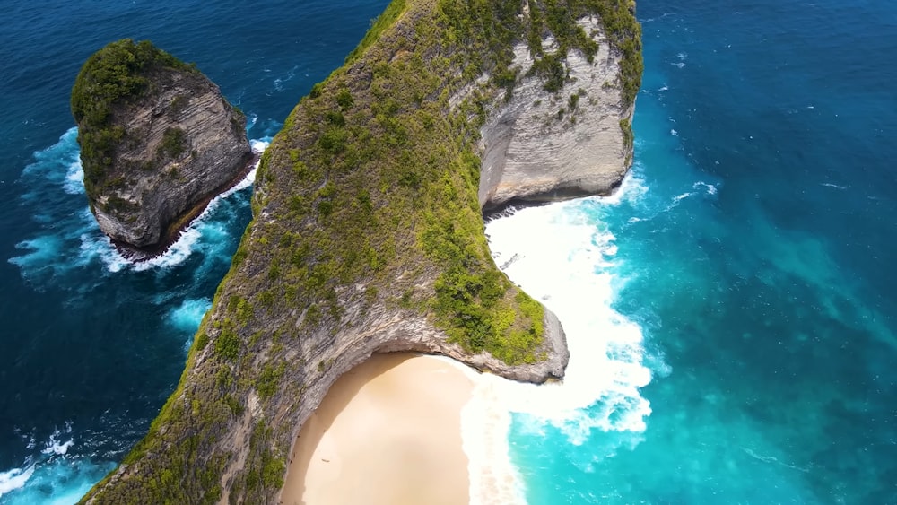 an aerial view of a beach with two large rocks