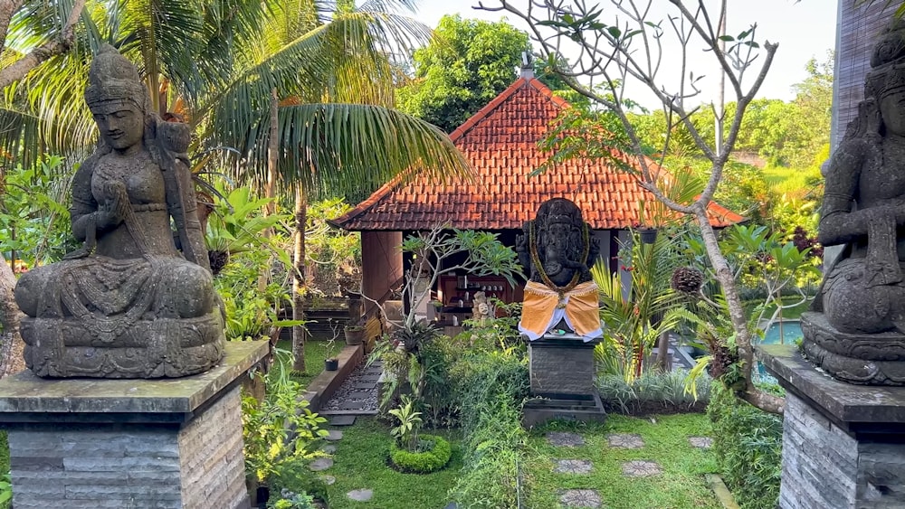 a garden with statues of buddhas and a gazebo