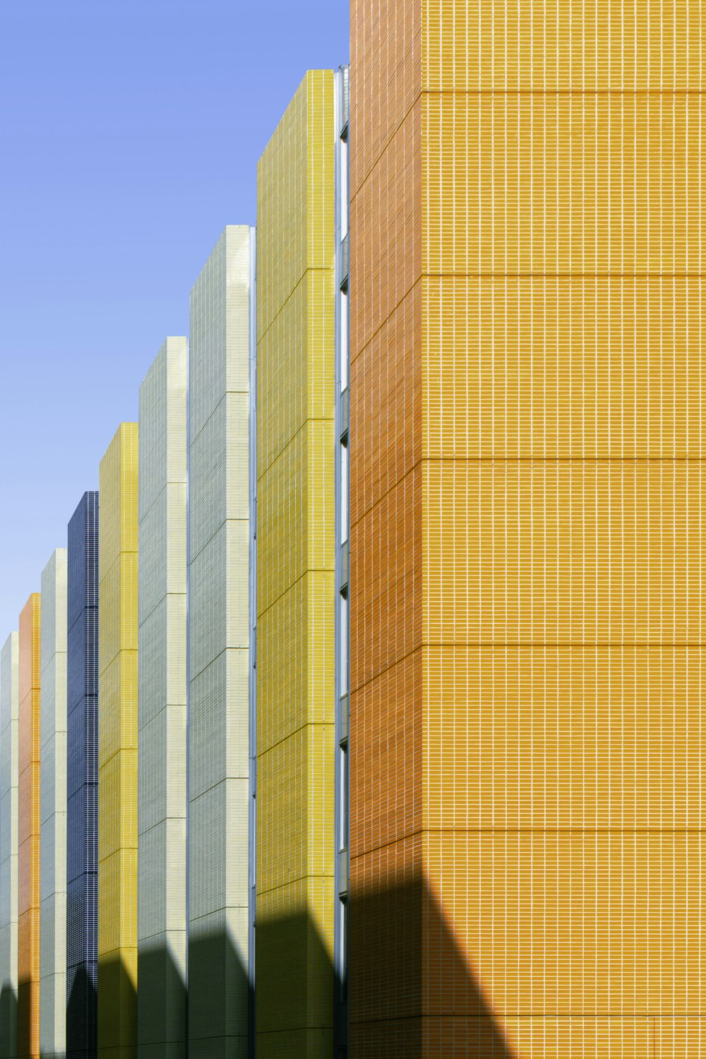 a row of yellow and grey buildings against a blue sky