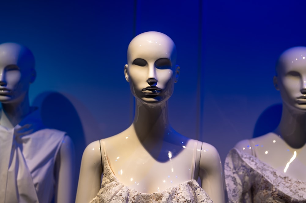 a group of mannequins wearing white clothing