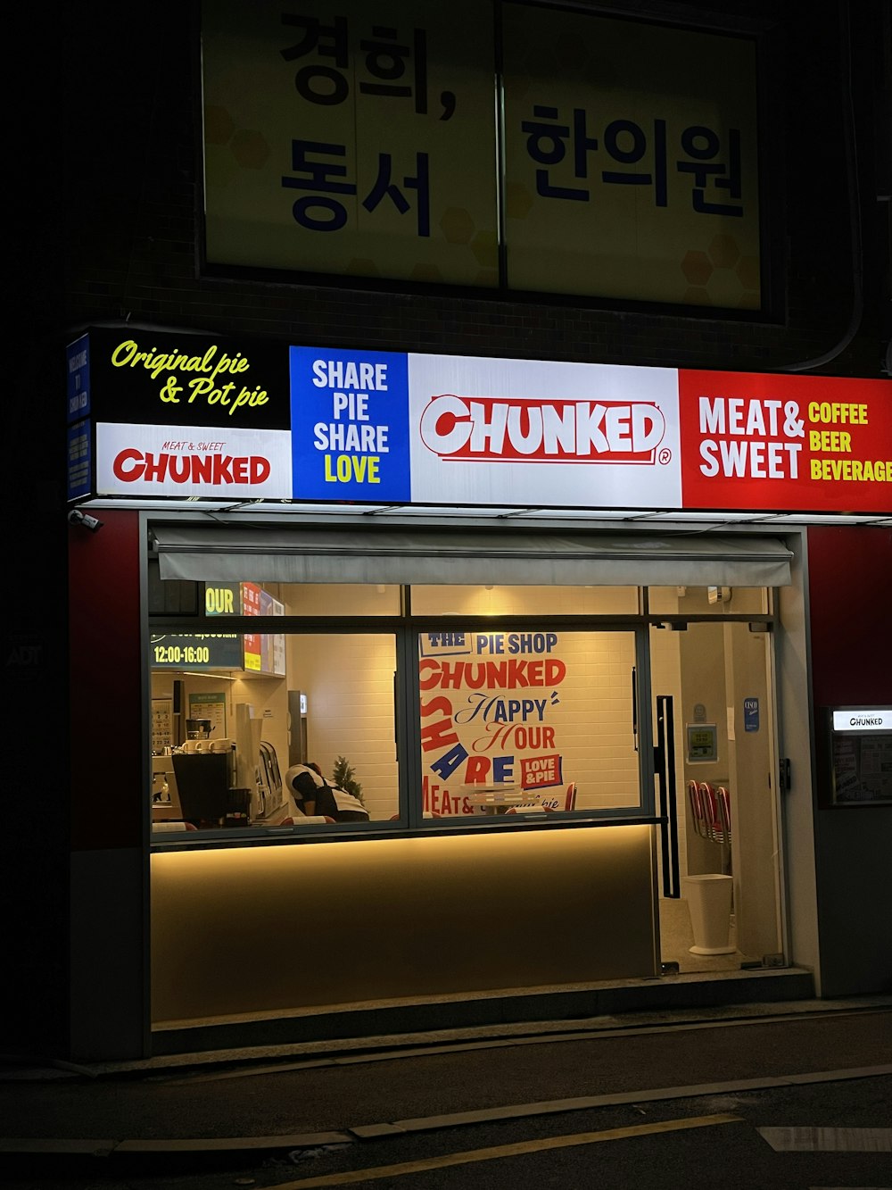 a store front at night with a lit up sign