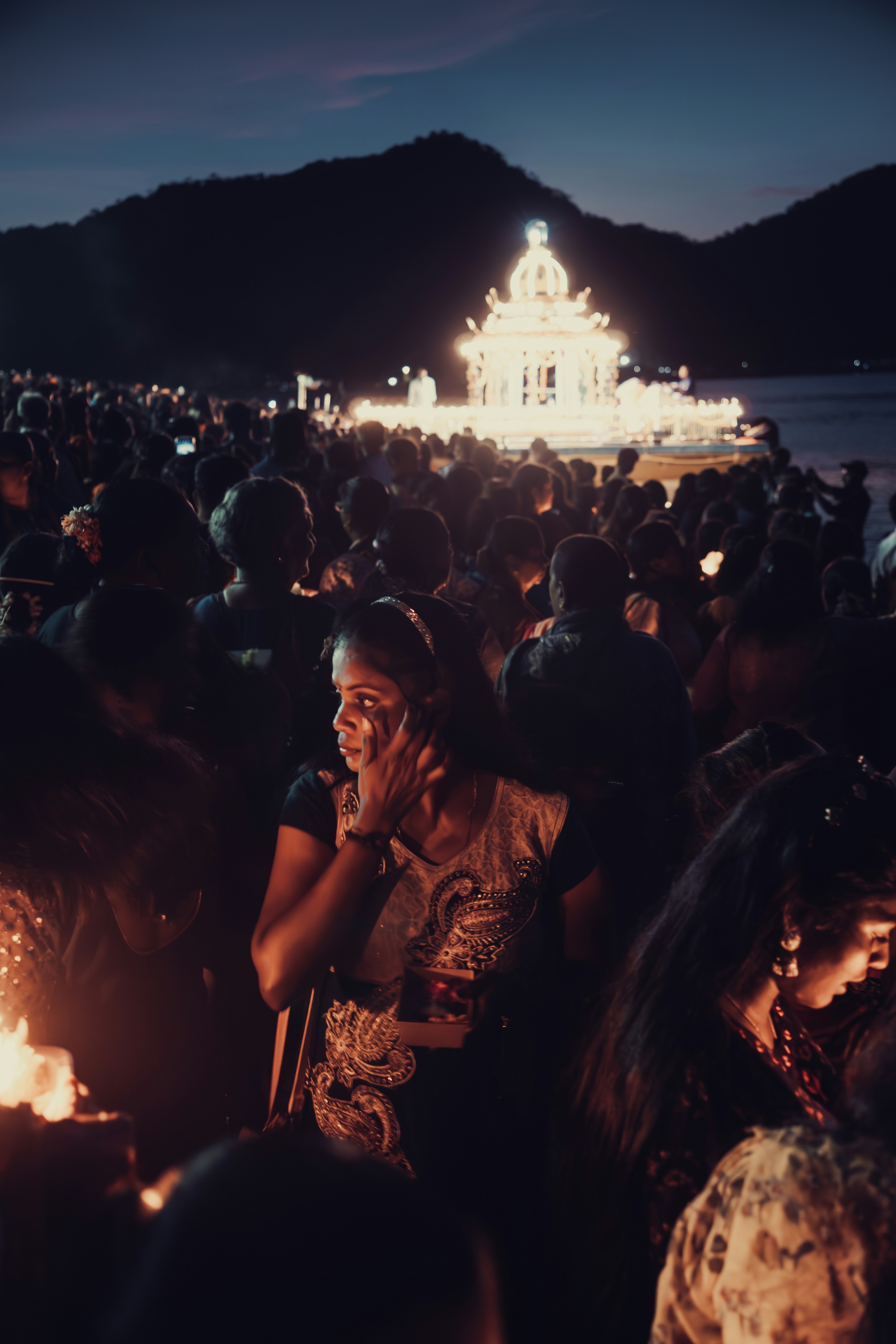 A crowd of people standing around a fire pit