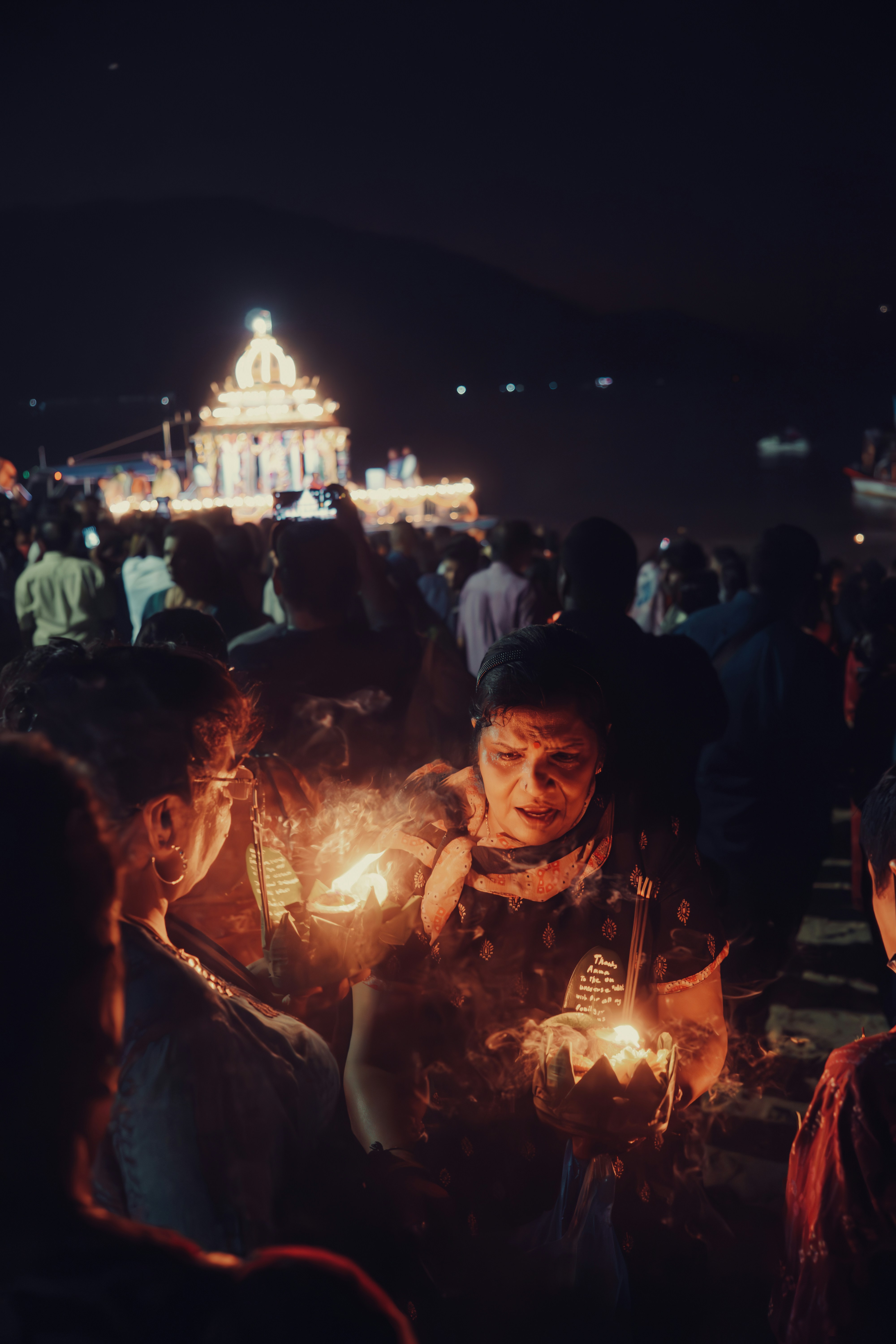 A group of people standing around each other holding candles