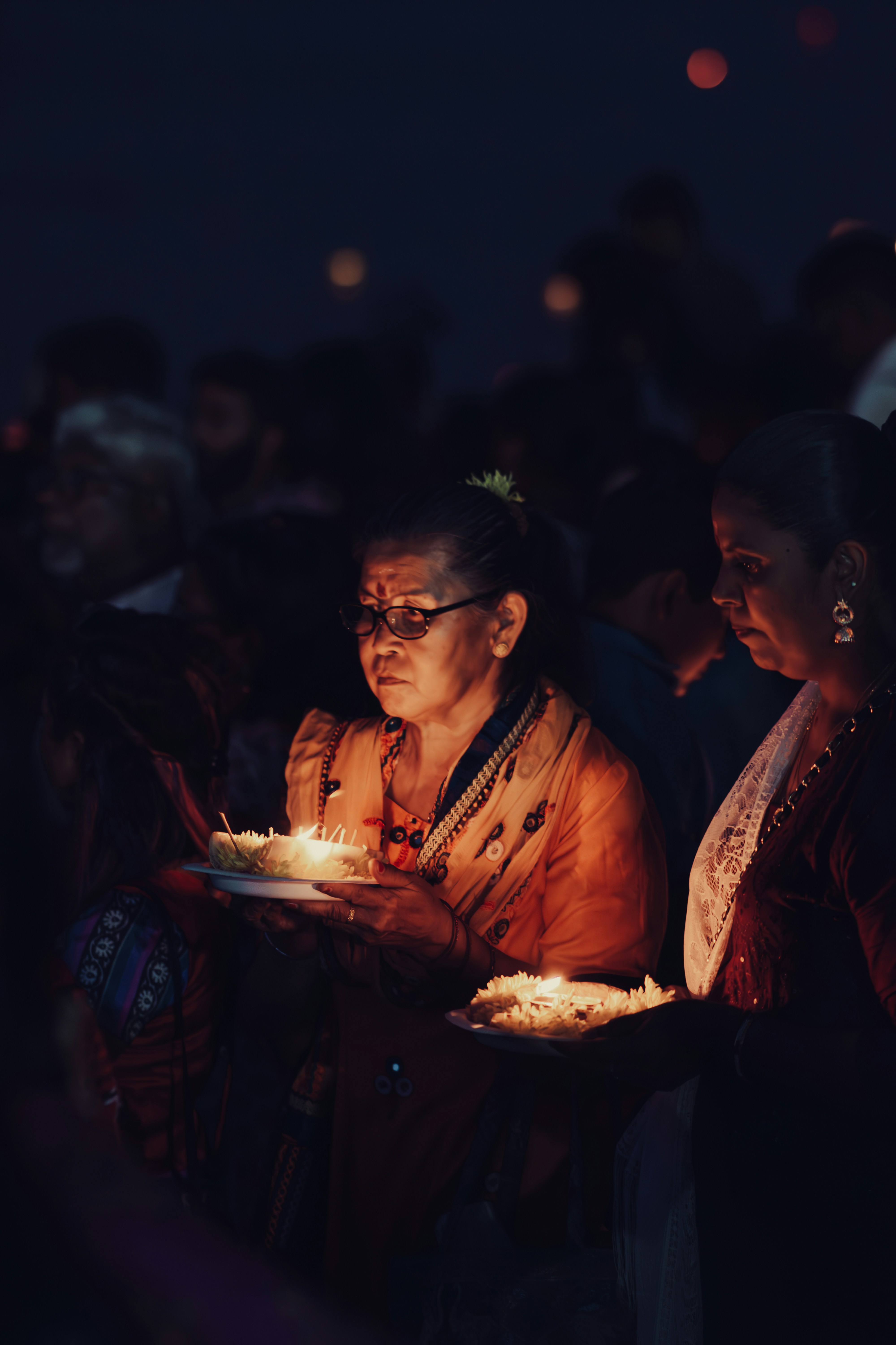 A group of people standing around a cake