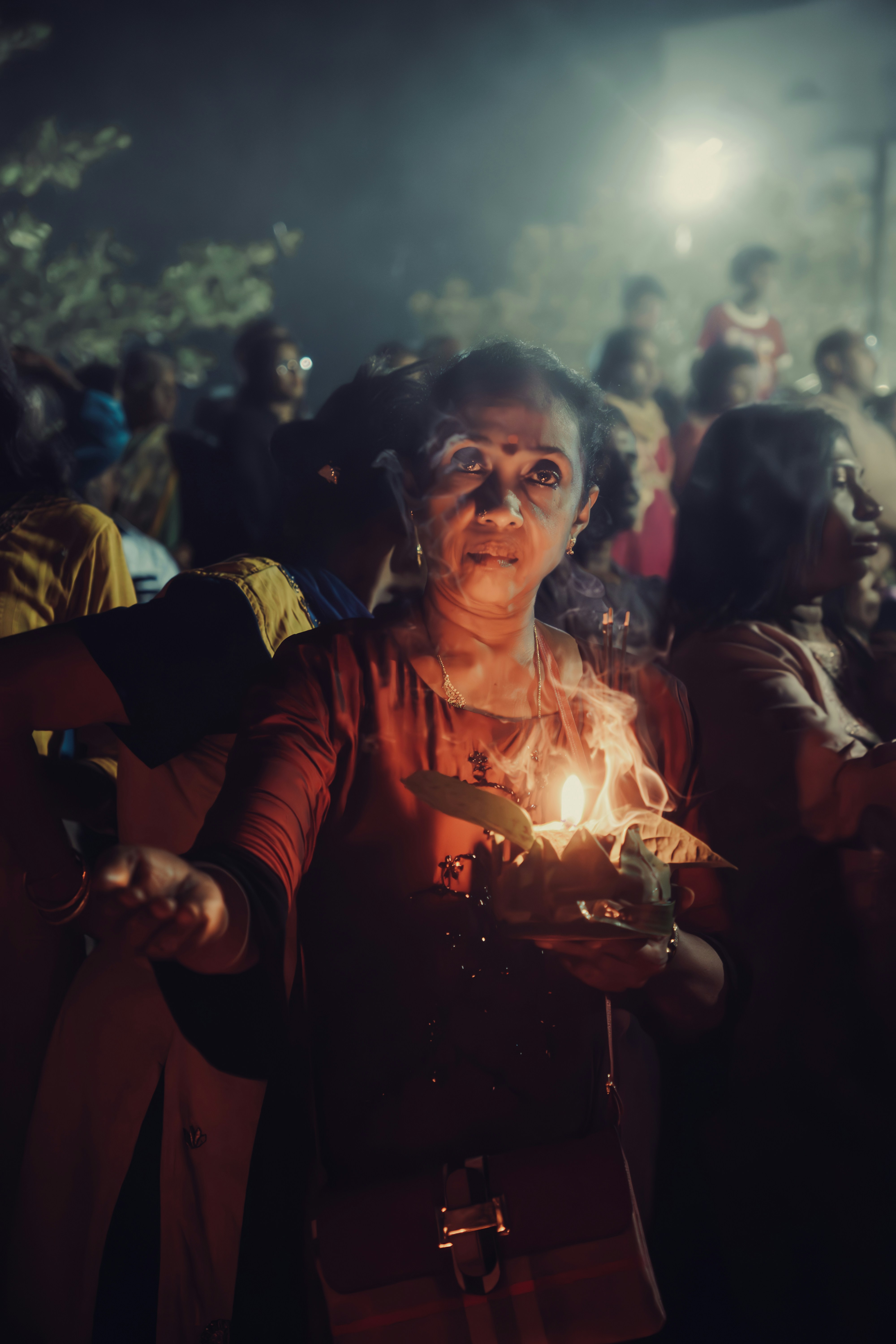 A woman holding a lit candle in her hands