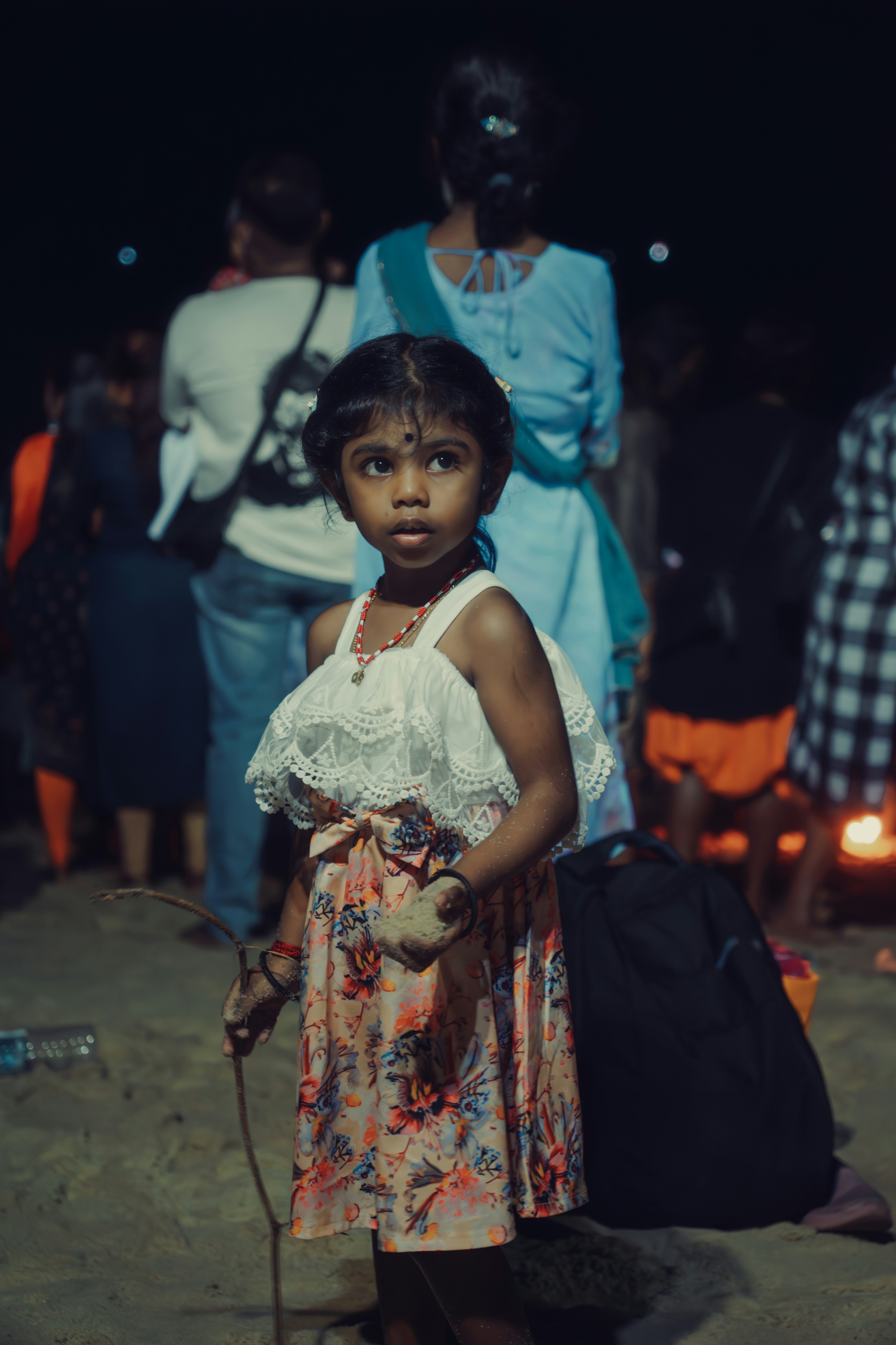 A little girl standing in front of a group of people