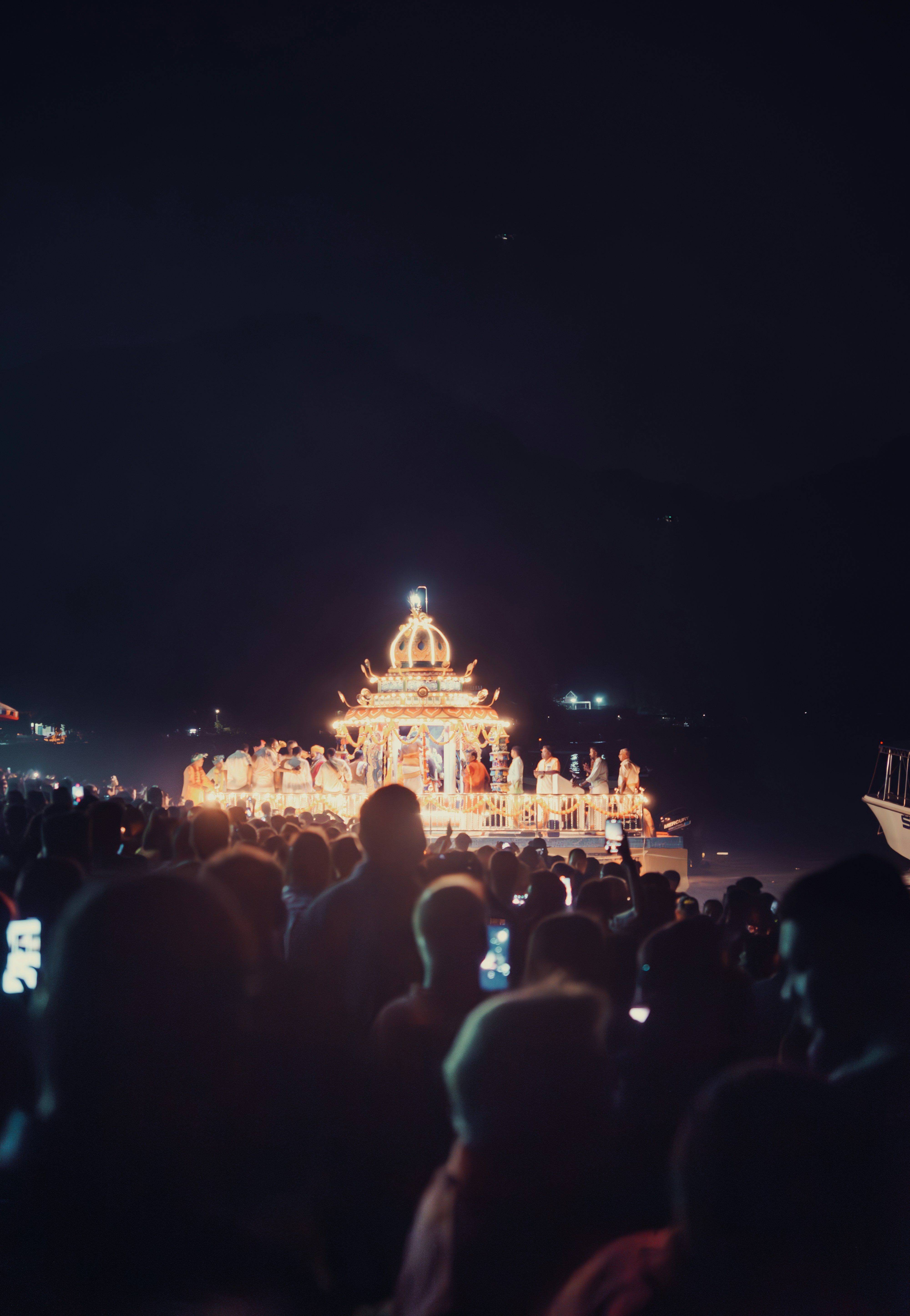 A crowd of people standing around a building at night