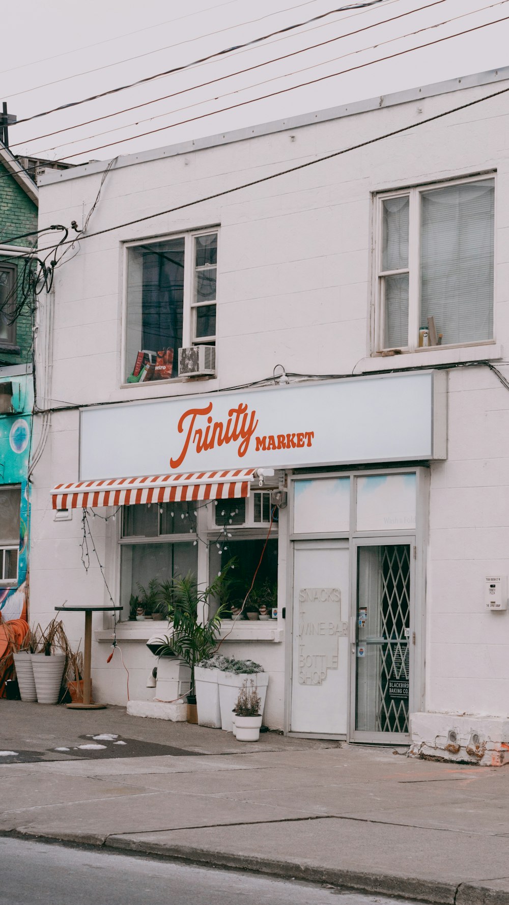 a white building with an orange and white awning