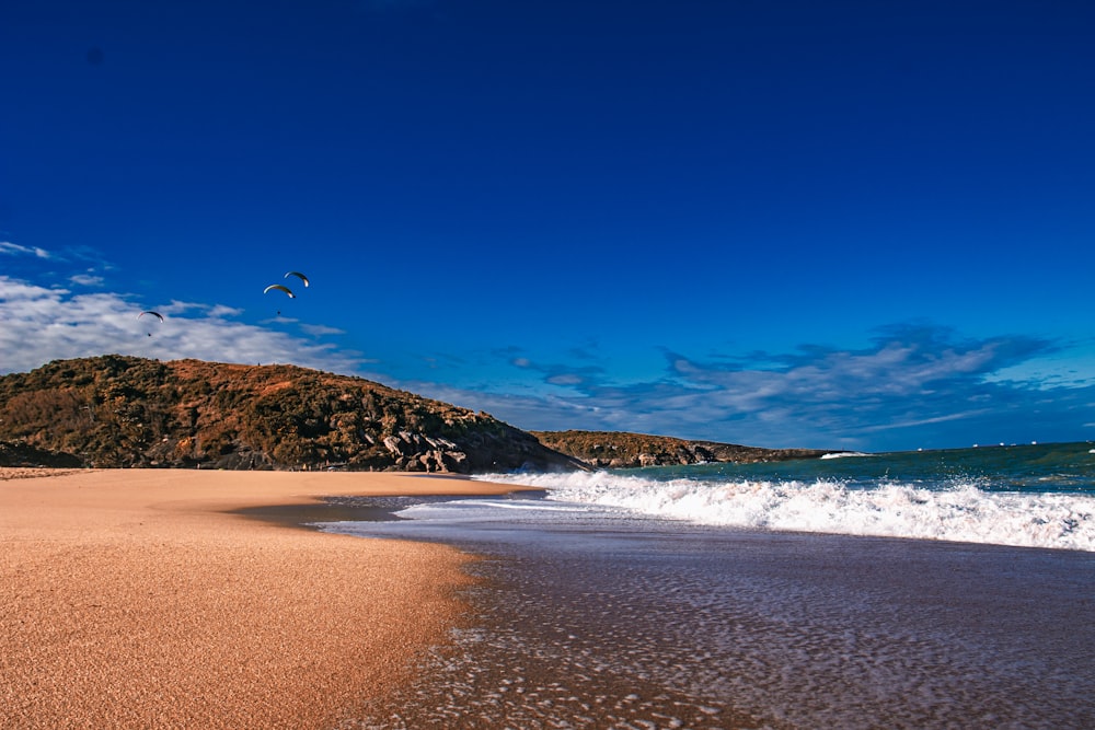 a sandy beach with waves coming in to shore