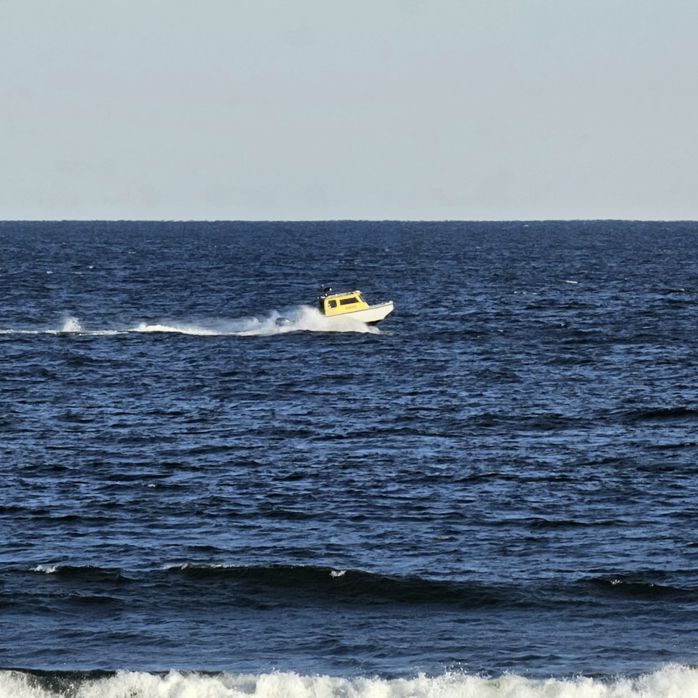 a small yellow boat in the middle of the ocean