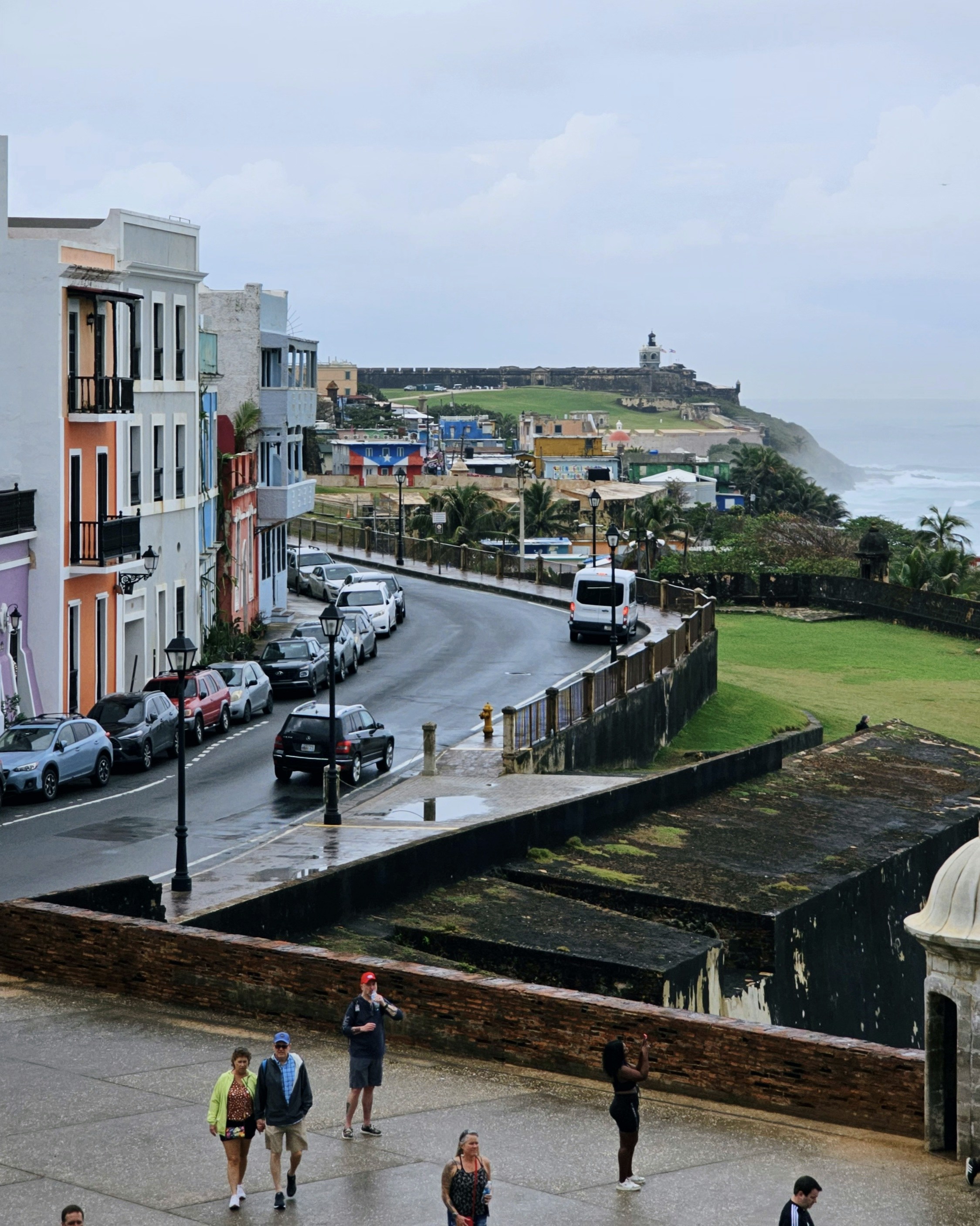 a group of people walking down a street next to tall buildings