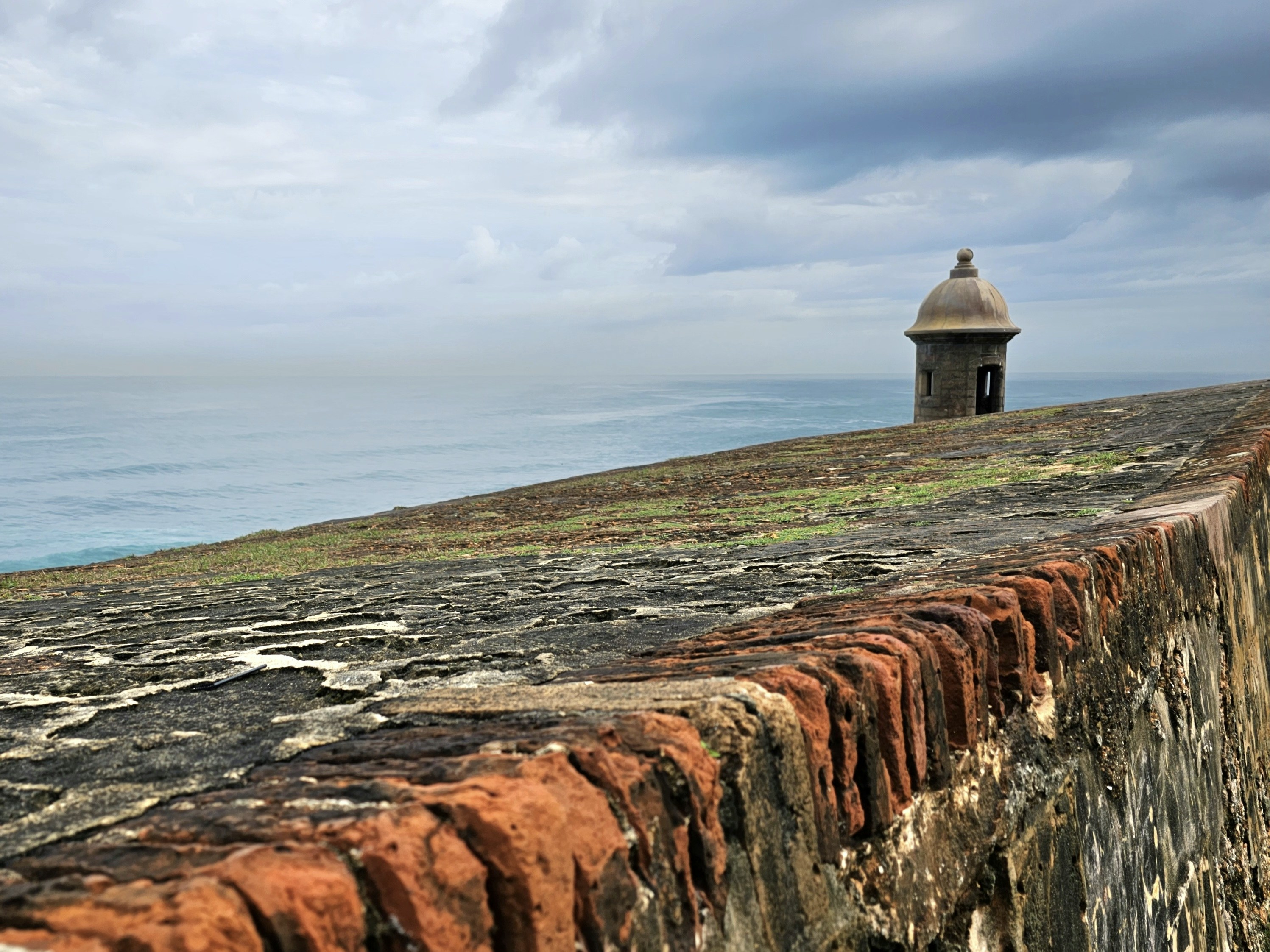a stone wall with a small building on top of it