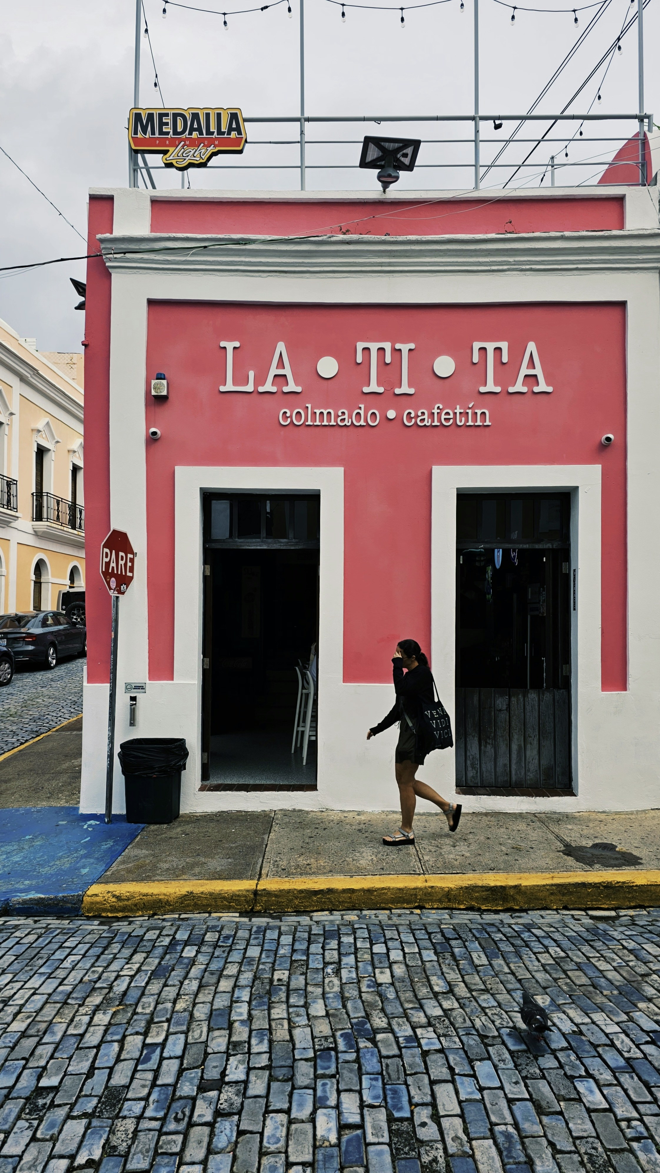 a woman walking past a red and white building