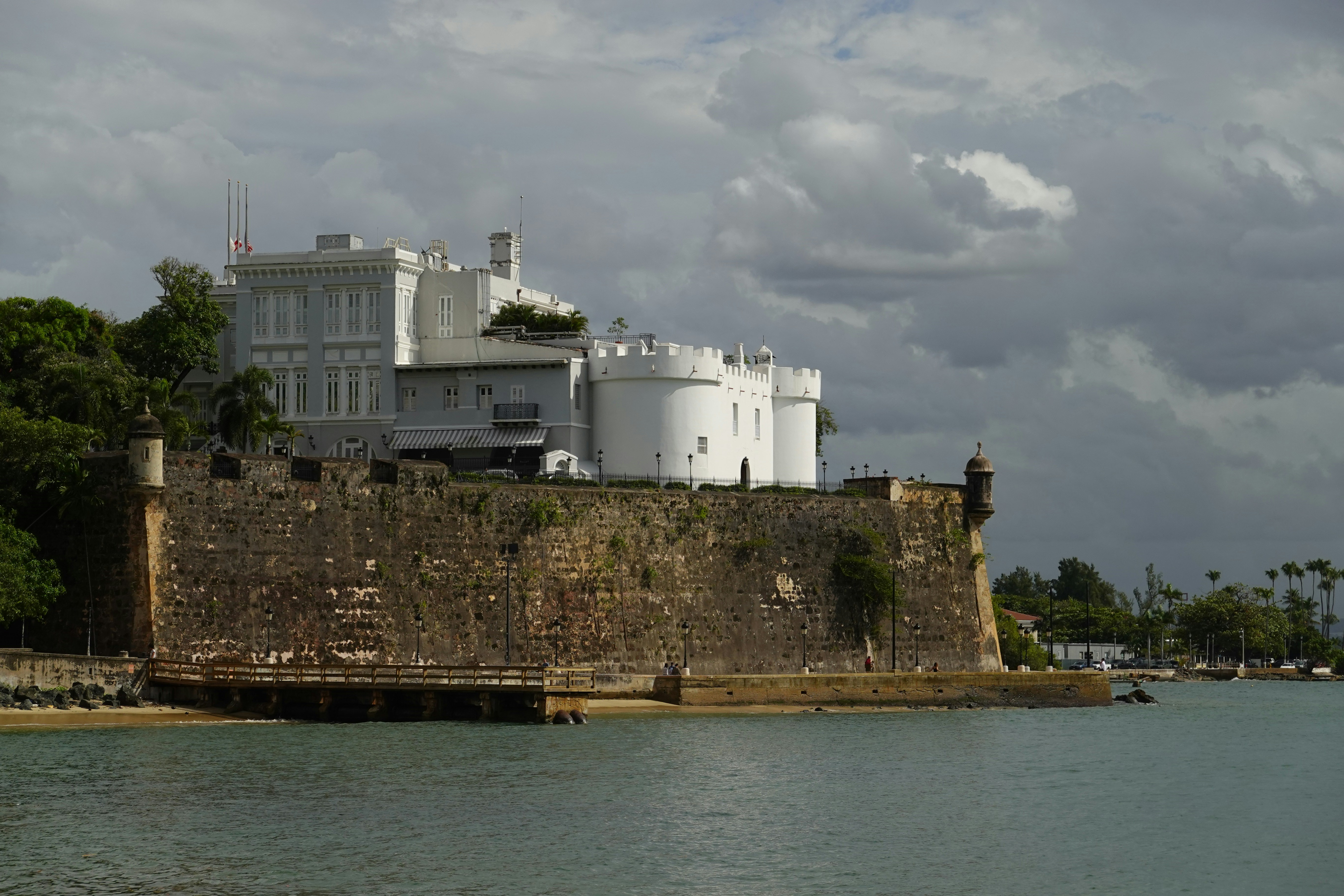 a large white building sitting on top of a stone wall