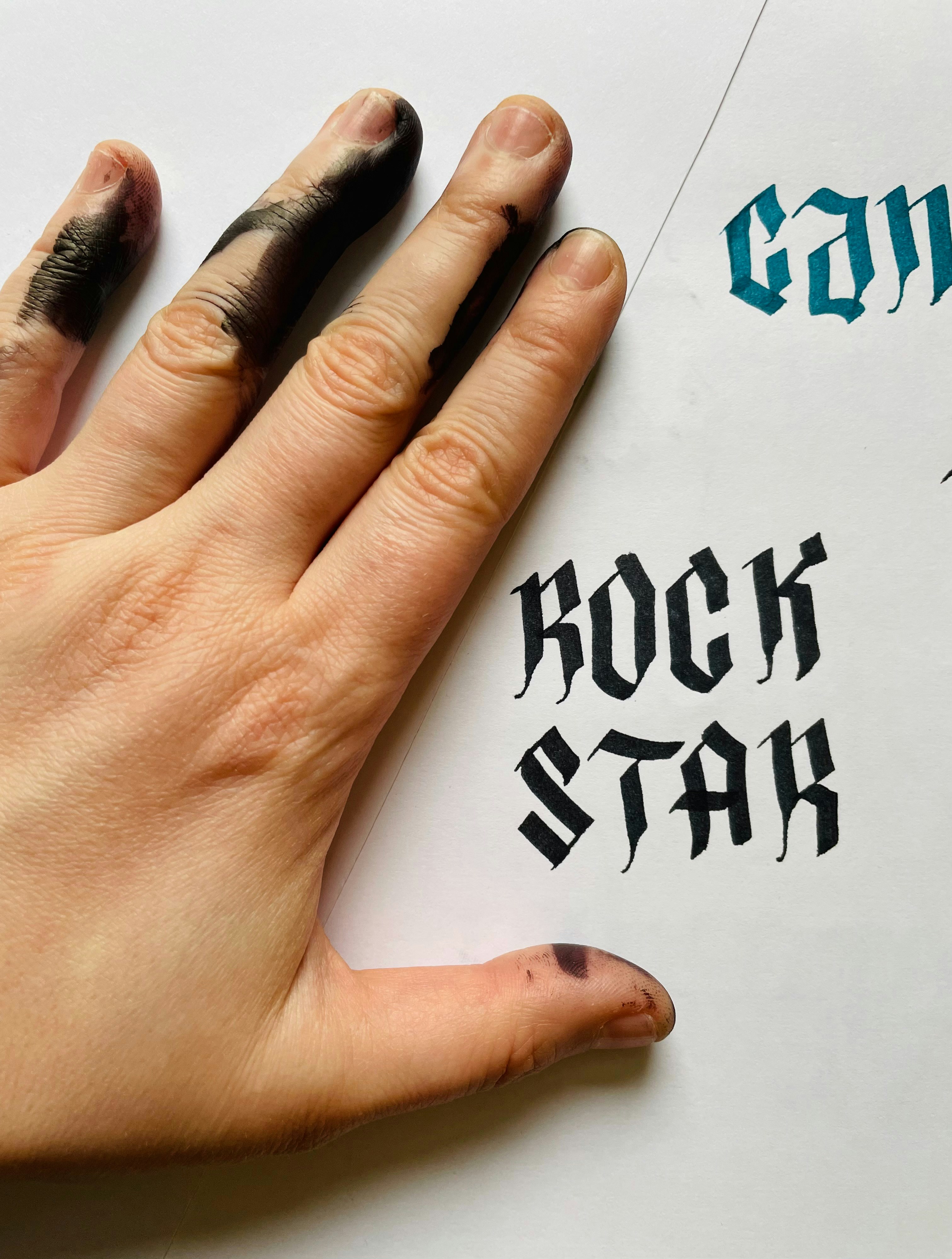 la mano de una persona encima de un pedazo de papel con una escritura en ella