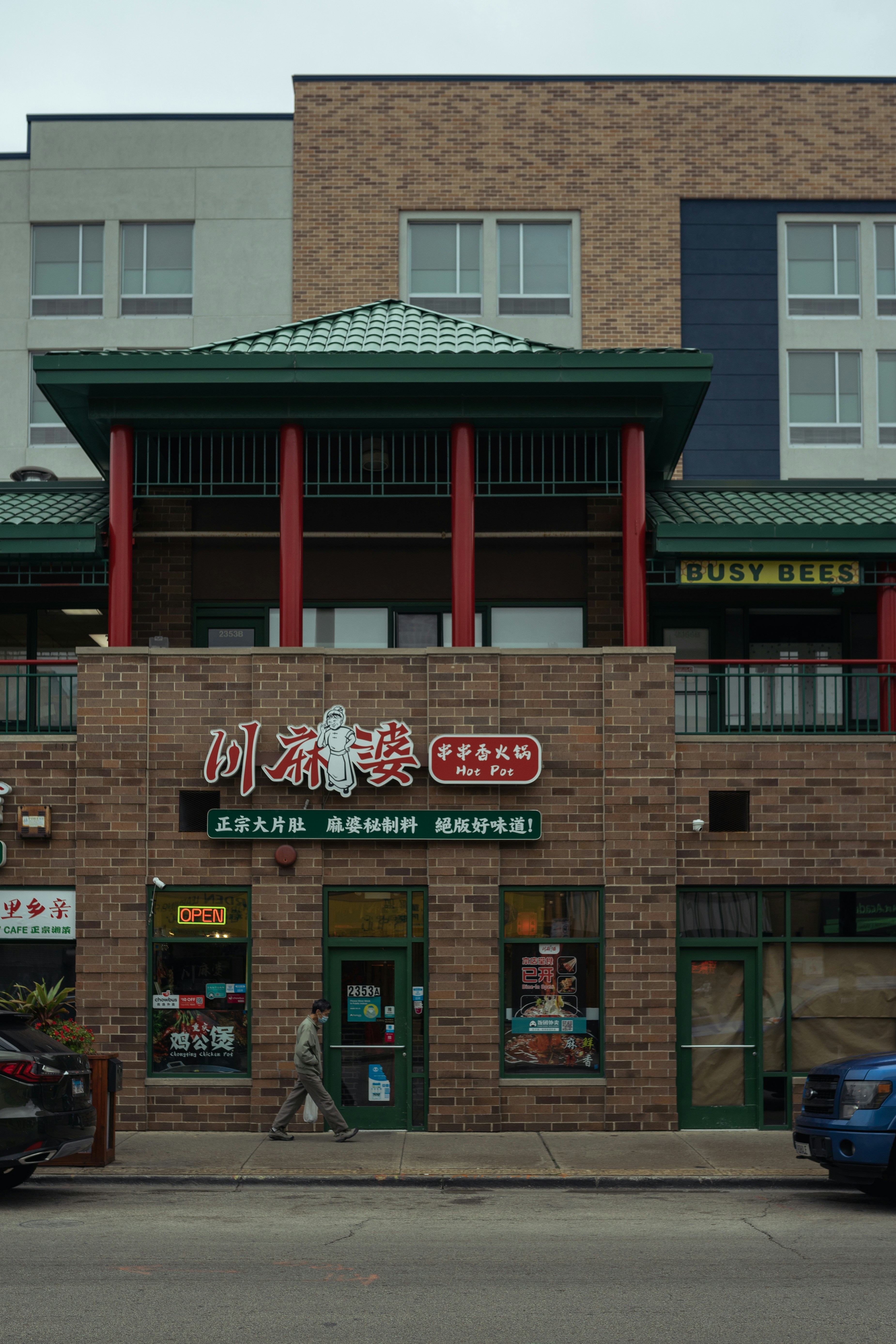 a brick building with a green roof and red columns