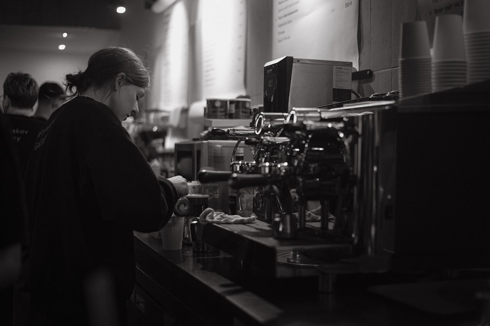 a black and white photo of a woman at a coffee shop