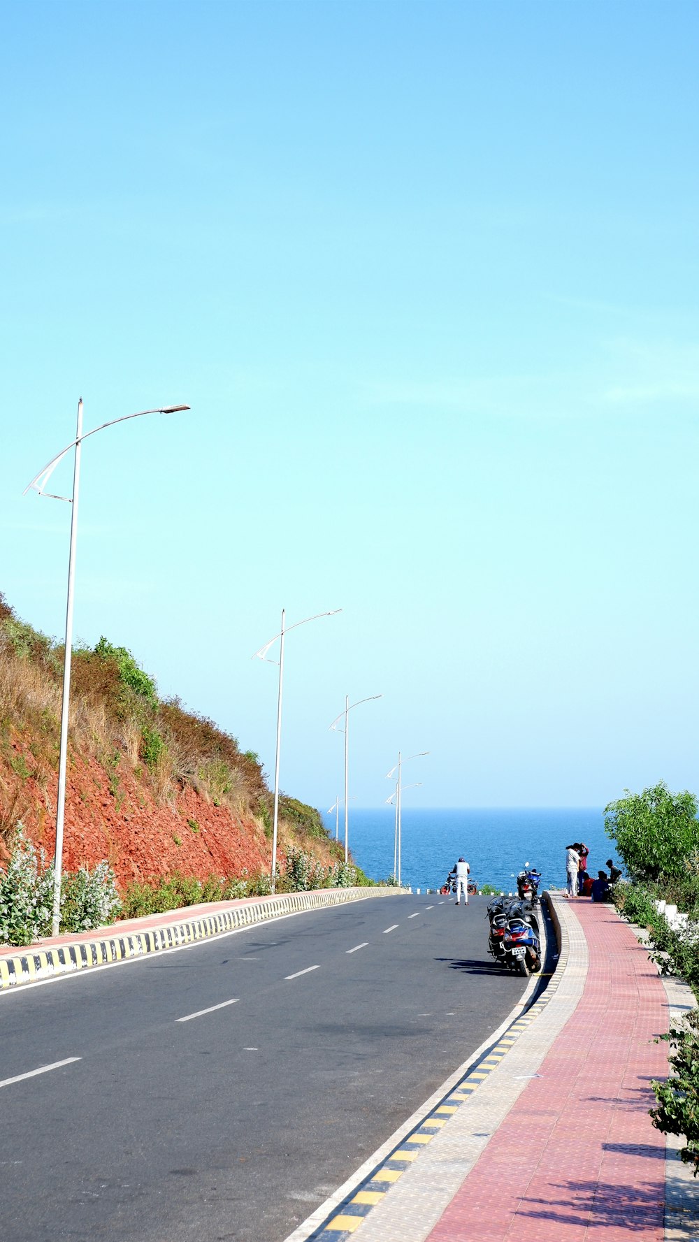 a motorcycle parked on the side of a road next to the ocean