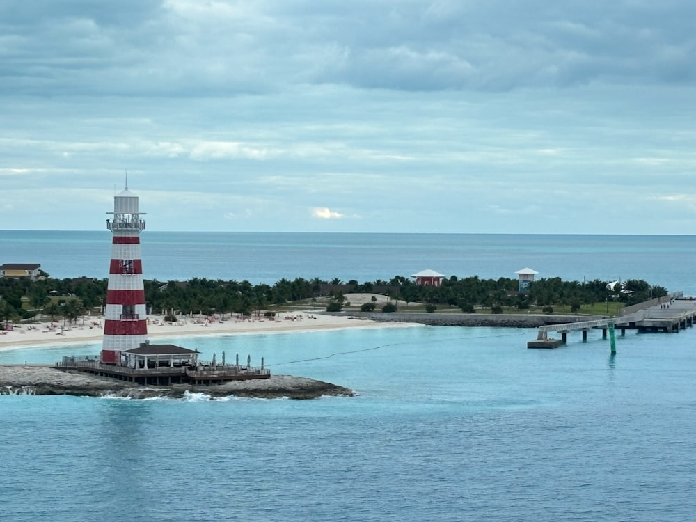 a red and white lighthouse sitting on top of a pier