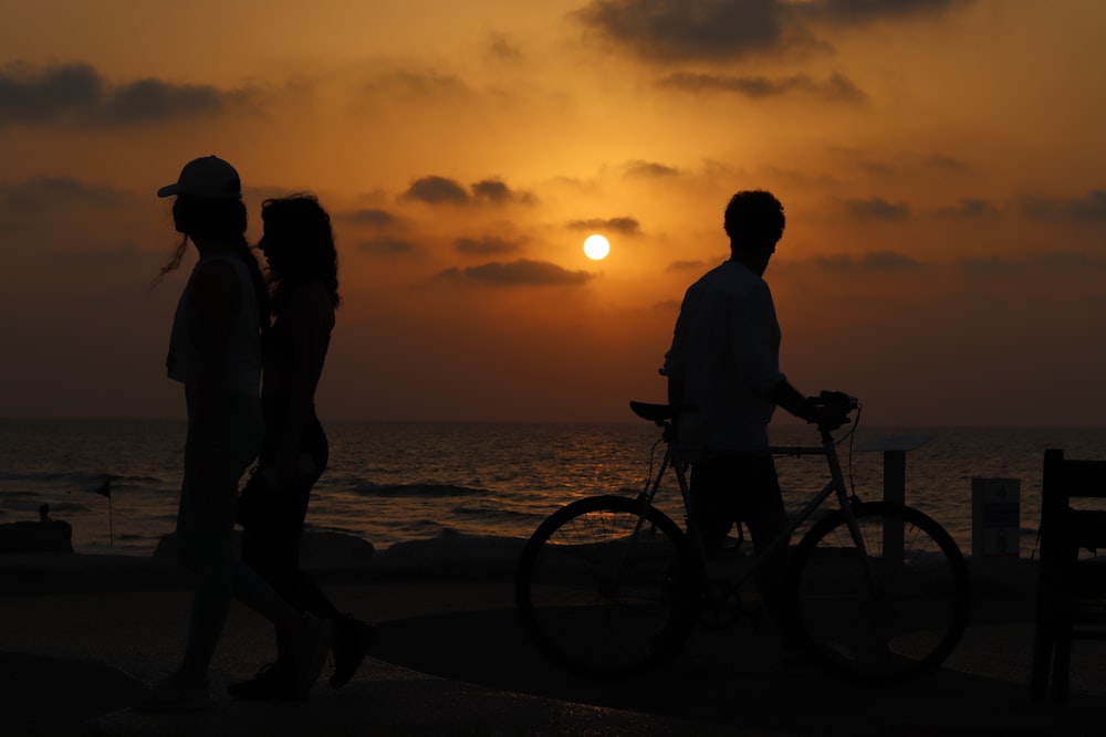 a man and a woman standing next to each other near the ocean