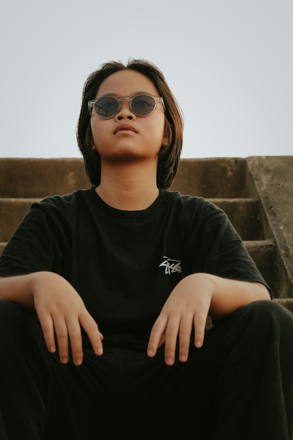 a person sitting on some steps wearing sunglasses